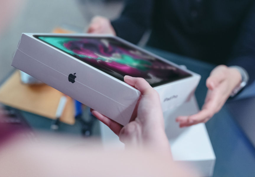 a customer holding a tablet in new packaging