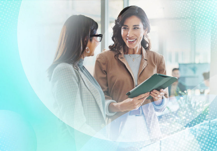 Two professional women smiling and discussing AI on a tablet, with a light blue abstract pattern overlaying the image.