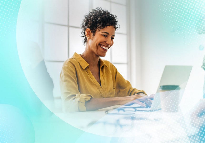 A smiling professional working with enhanced productivity on a laptop in a modern office