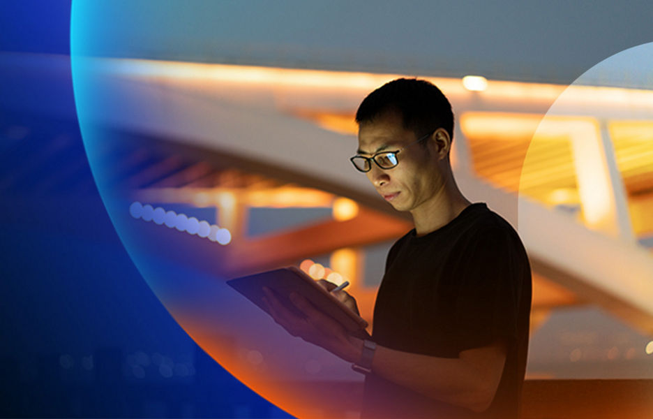 Person using a tablet outside with an urban architectural structure in the background