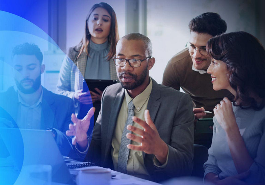 A diverse team engaged in a discussion around a laptop