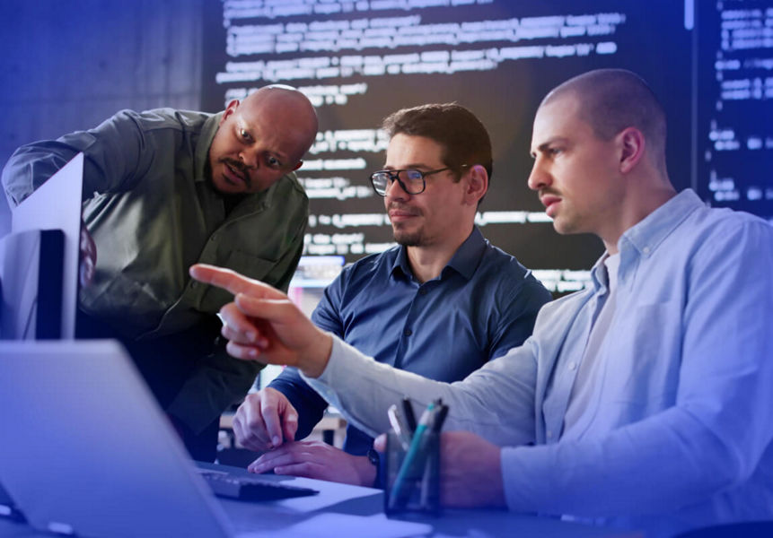 A team of software engineers testing applications in front of multiple screens
