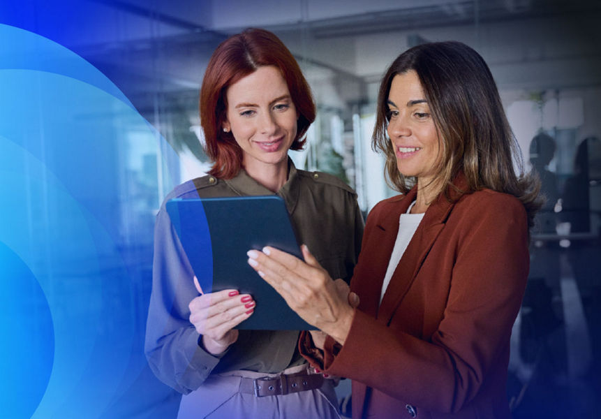 Two professionals holding a tablet, attentively looking at it and engaged in discussion.