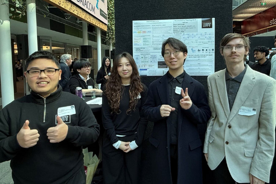 Four AUT BCIS students smiling at a careers event on campus.