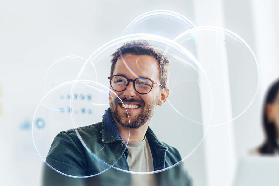A man smiling standing in front of a whiteboard.