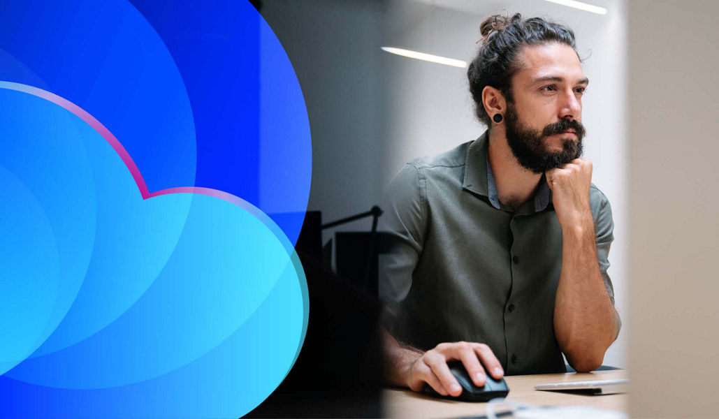 A man with a beard working at a computer