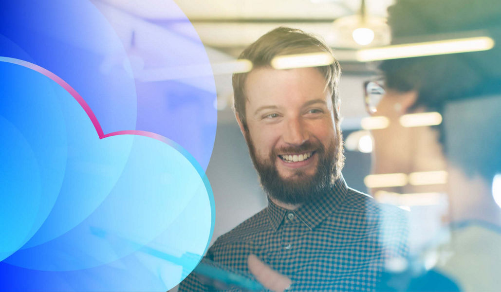 A smiling man talking to a cloud team colleague