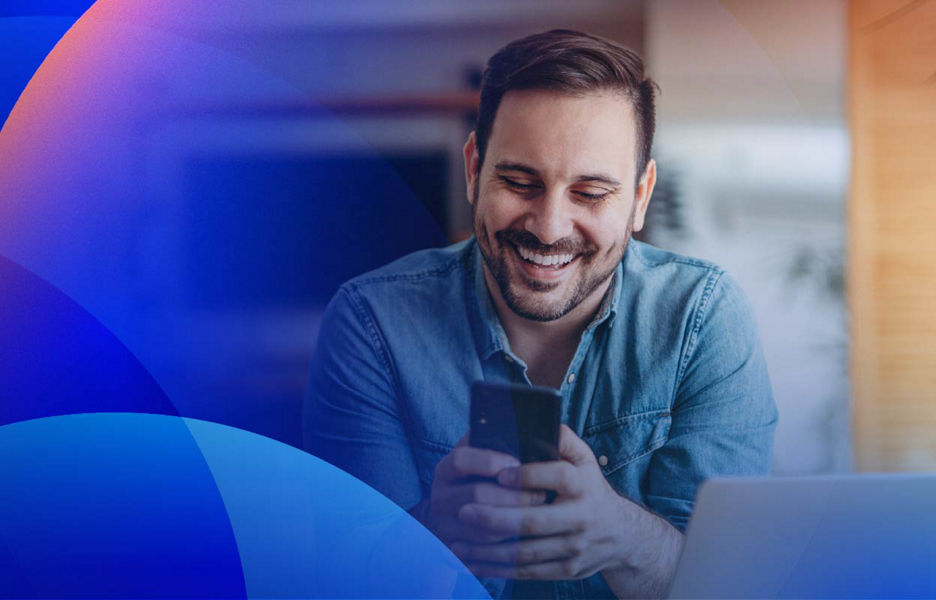 A smiling user looking at an app on a smartphone.