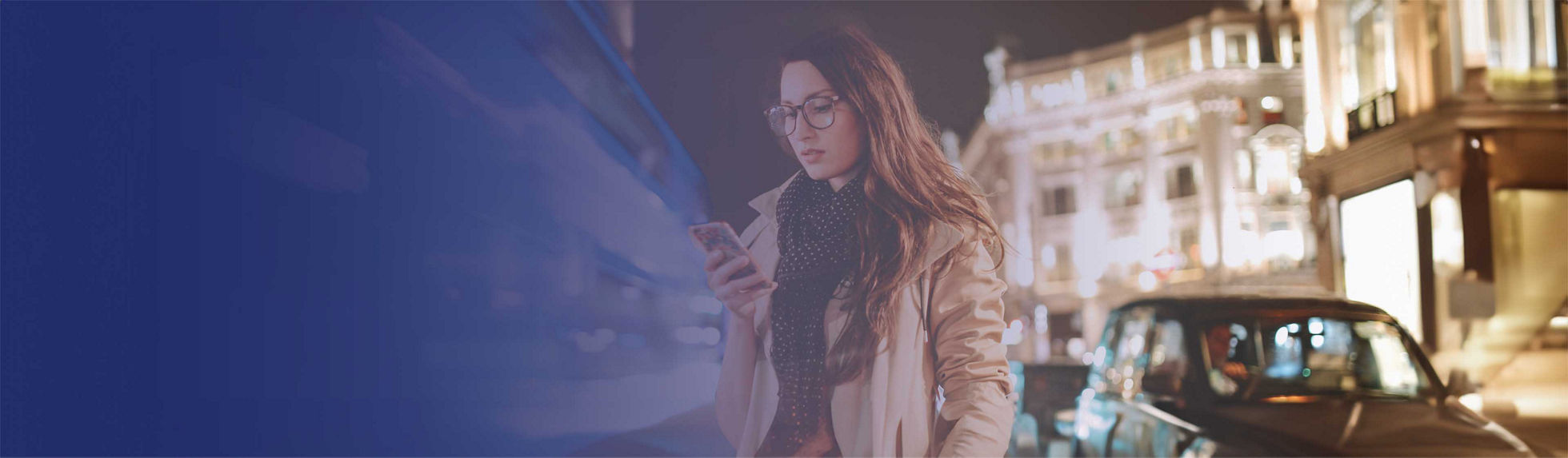 A young woman using a laptop in front of a city skyline