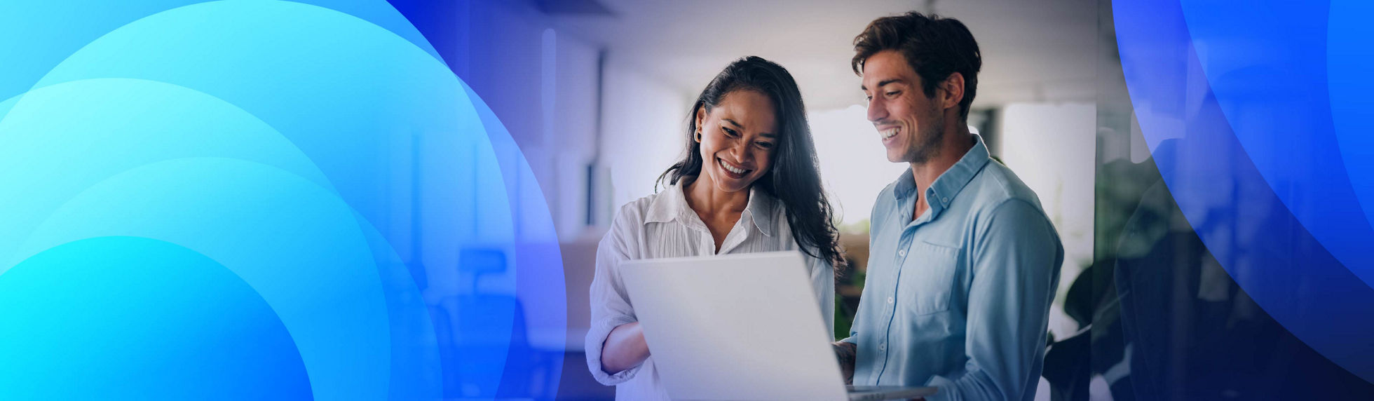 Two happy professionals woking with modernised applications on a laptop 