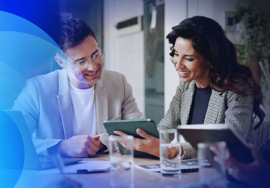 Professionals sitting in a meeting, exploring modernised apps on a digital tablet.