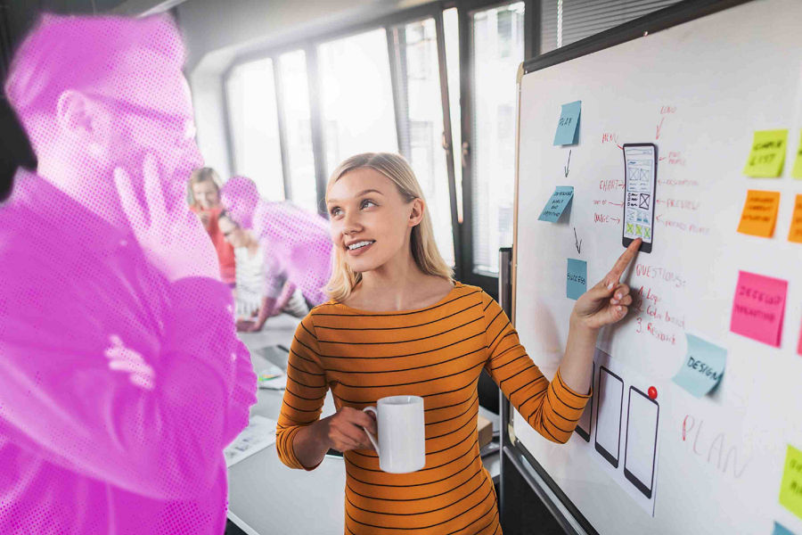 Woman brainstorming on a whiteboard with her colleague 