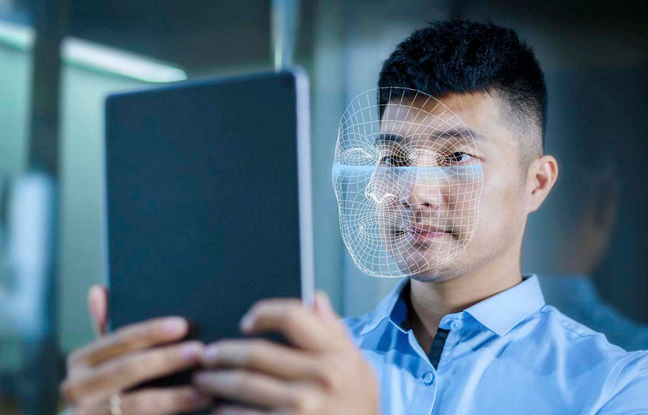 A man holding a tablet up in front of his face