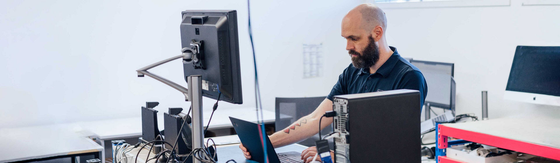 A Datacom asset recovery specialist fixing a laptop