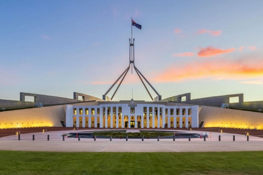 Australian parliament building at sunset, walls lit with yellow light