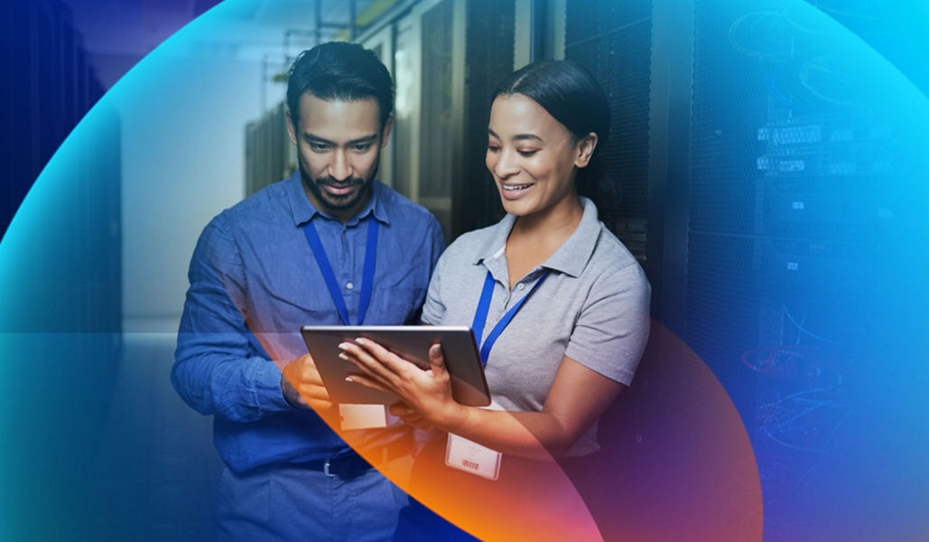 A man and a woman in a data centre looking at a tablet