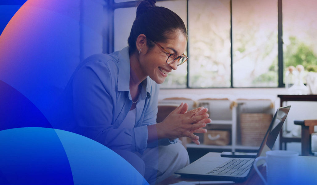 Happy customer sitting in front of a laptop while receiving support from a contact centre.