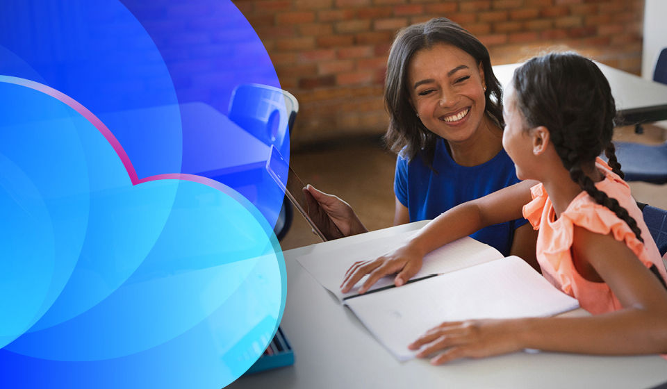 A teacher and child smiling at a desk