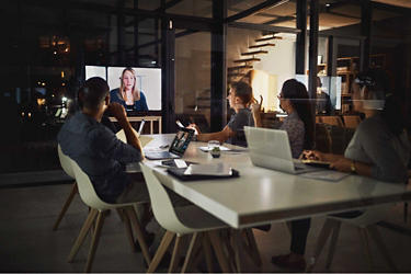 Workers having a digital and physical meeting in a meeting room