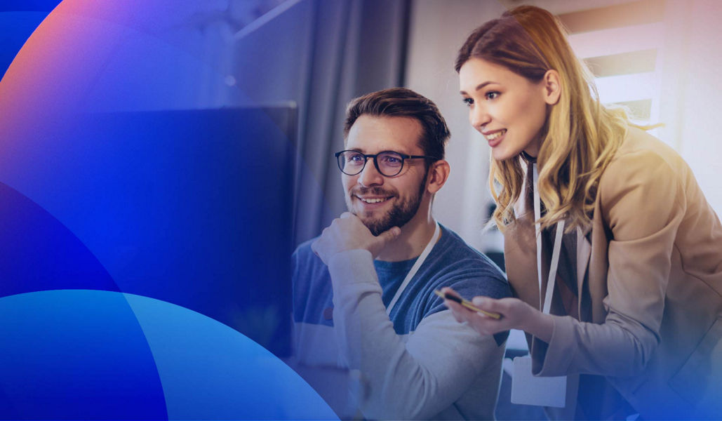 Two professionals collaborating at a computer, reviewing a CRM implementation to improve customer data management and business processes.