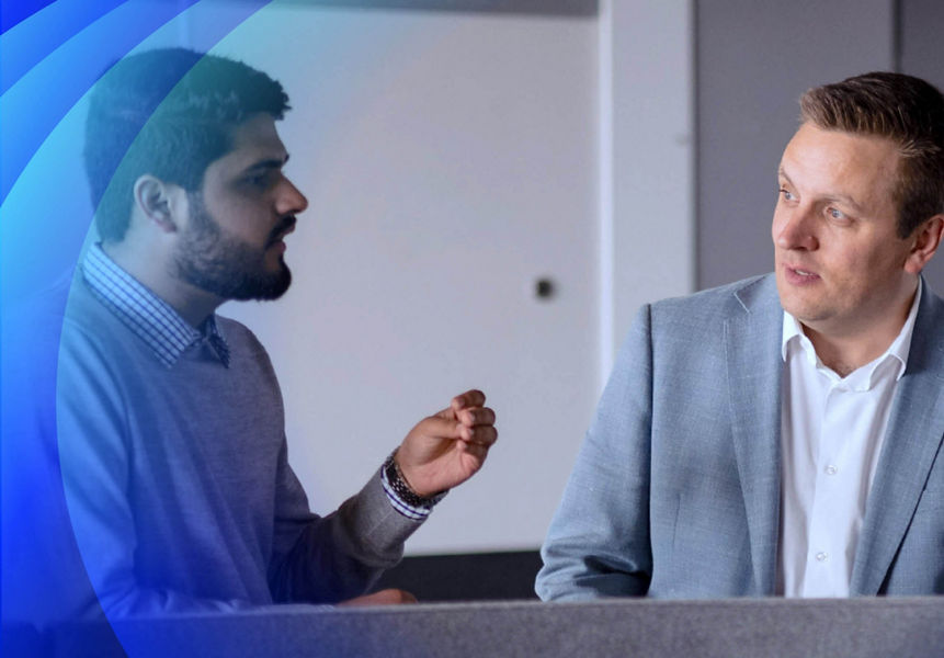 Three businessmen having a discussion in front of a whiteboard