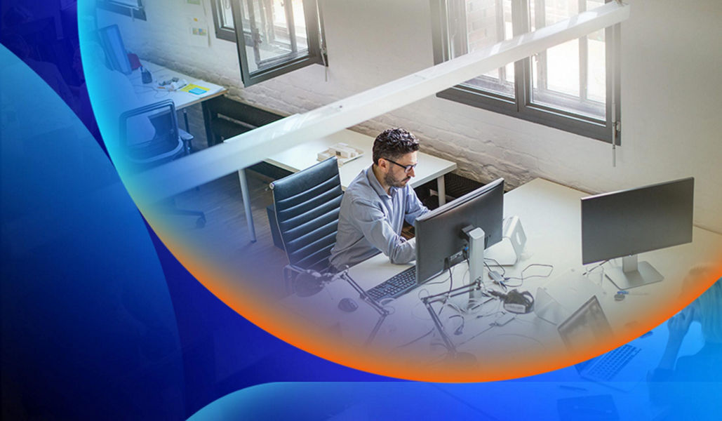 Man at desk working in an office space from in a view from above him with an orange and blue lens overlay