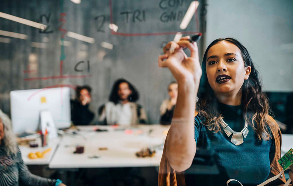 A woman running a workshop writing on glass