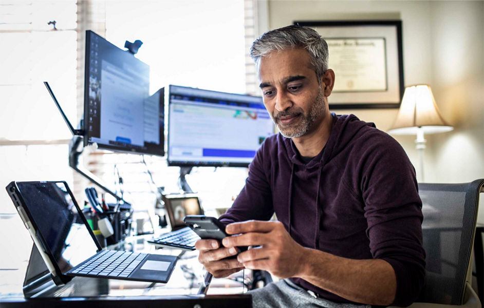 A man working from home checking his mobile phone