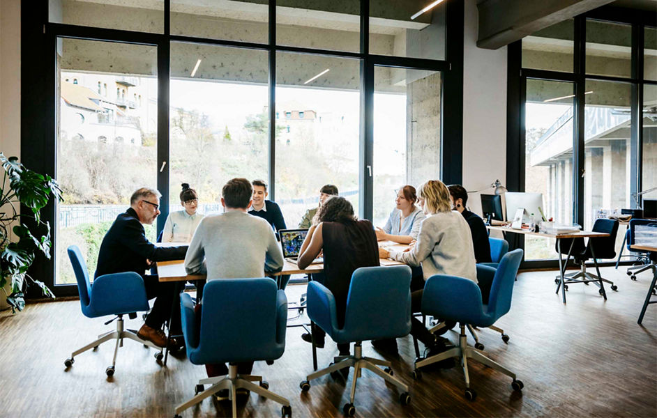 A large group of people having a discussion at a meeting table