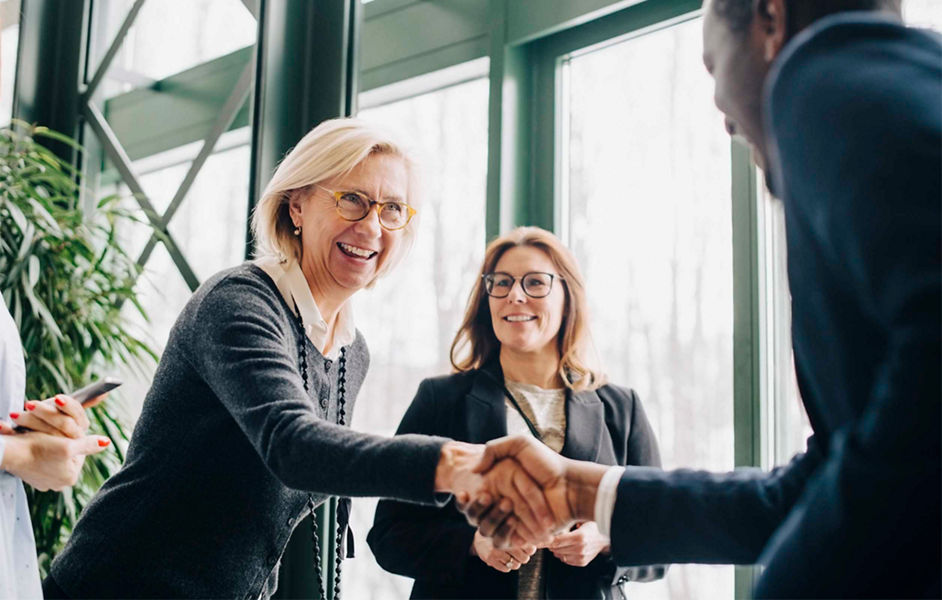 A smiling businesswoman shaking hands with a businessman 