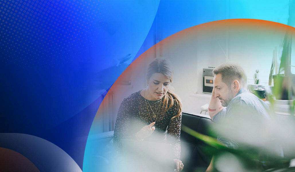 Two people having a conversation in an office with desks and indoor pot plants around them with an orange and blue lens overlay