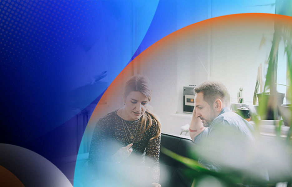 Man and woman at desk looking at laptop in office room