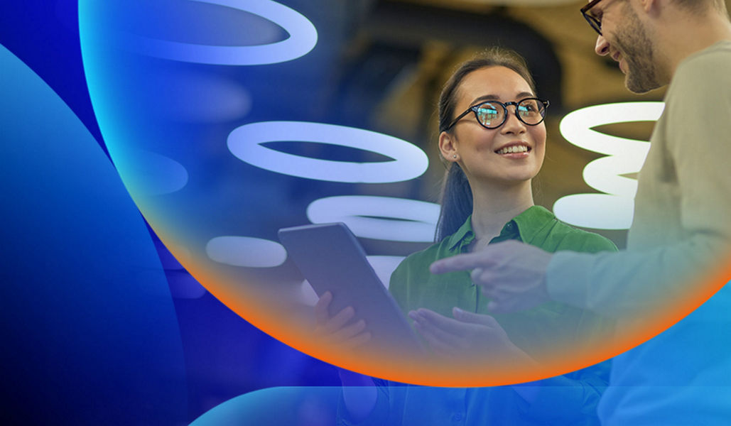 Woman with glasses holding an iPad while talking to a man with an orange and blue lens overlay