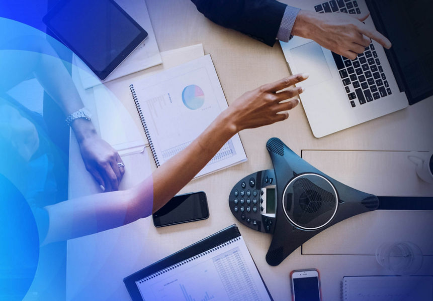 Birds eye view of a meeting with a conference phone on the table