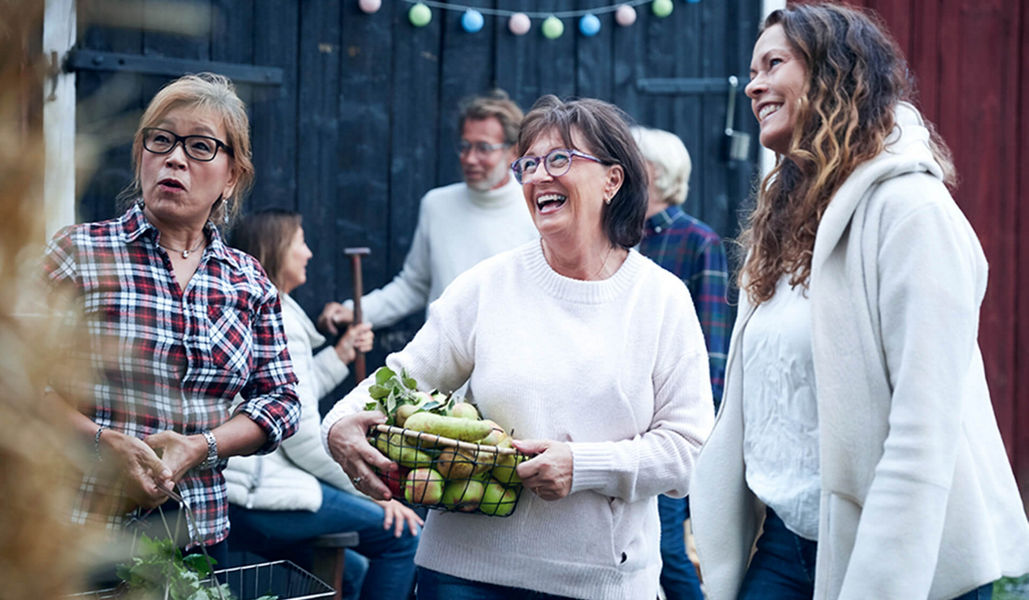 Three women smiling at a farmers market