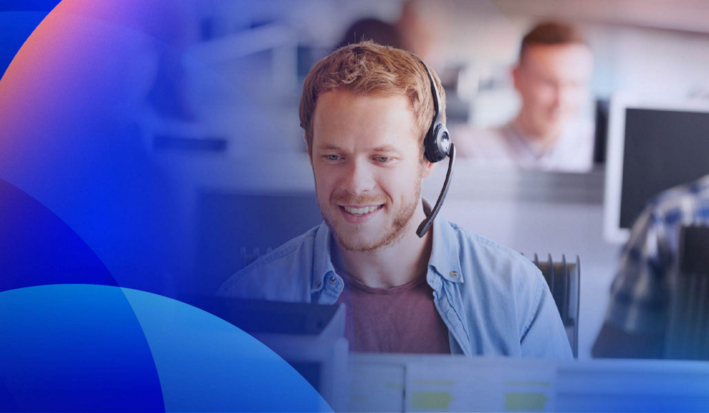 Smiling contact centre agent working in front of a computer