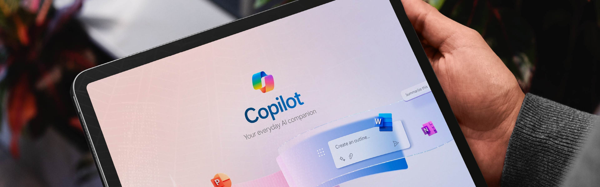 Man holding tablet with Copilot homepage showing on screen.