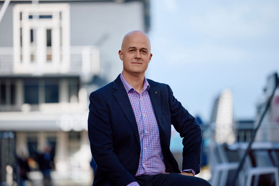 Mid distance shot of Dan Bowybes, Associate Director of Strategy at Datacom, in Poneke Wellington CBD, wearing blue blazer and blue checkered shirt.