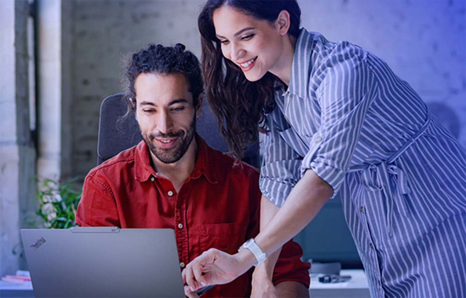 Man using laptop while woman hovers over shoulder