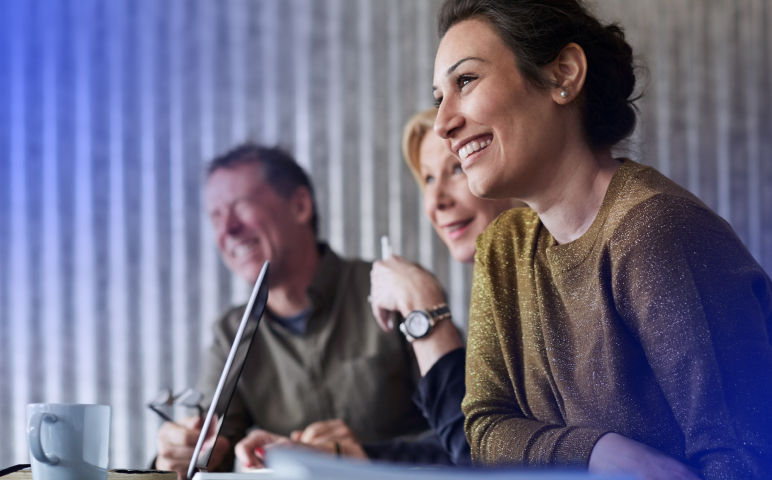 Happy Human Resource team sitting at conference table in a meeting