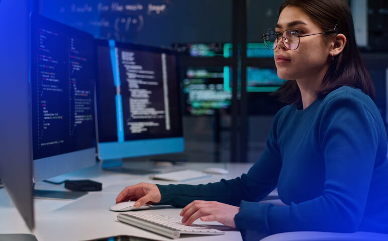 Woman wearing glasses sitting at desk using a computer