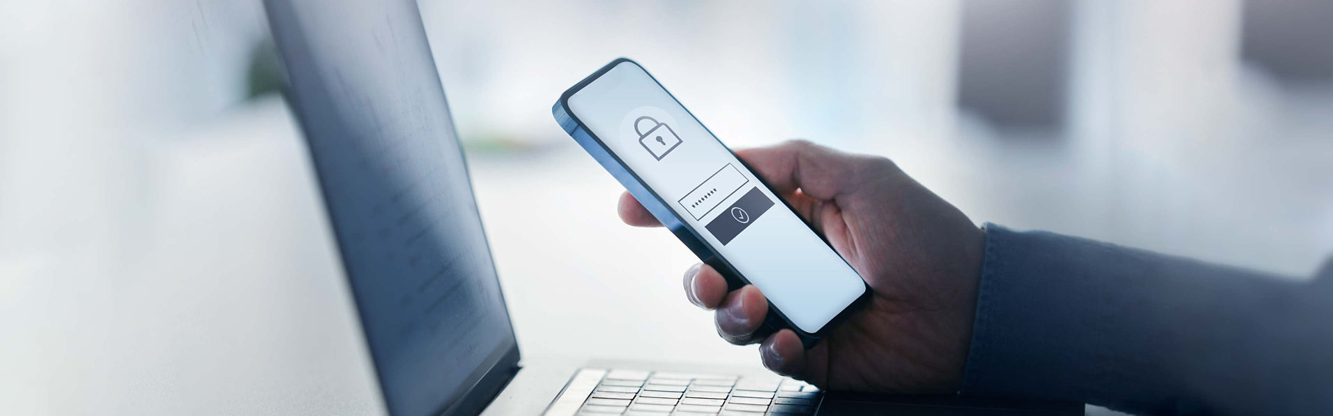Person holding smart phone with data security on display at office