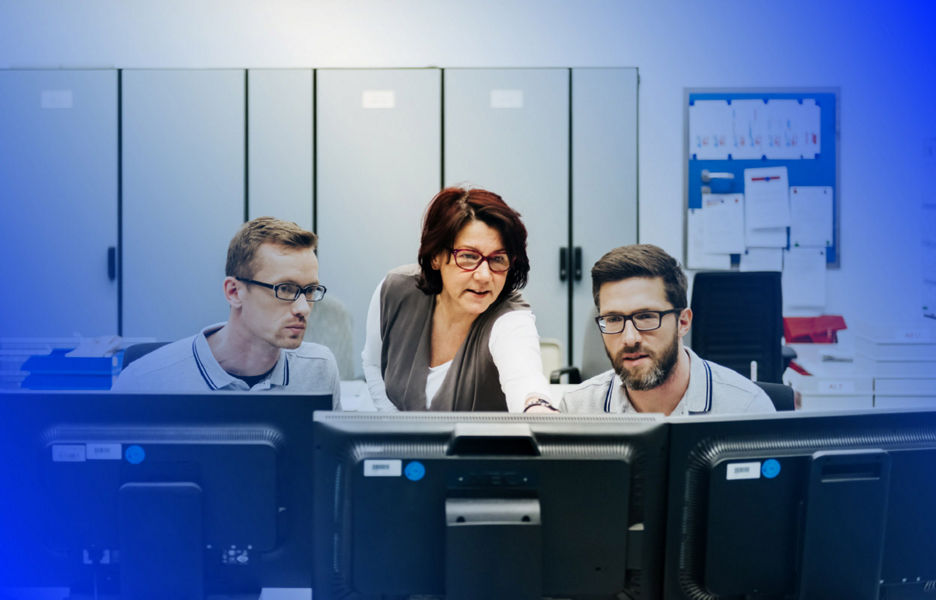 Man using laptop while woman hovers over shoulder
