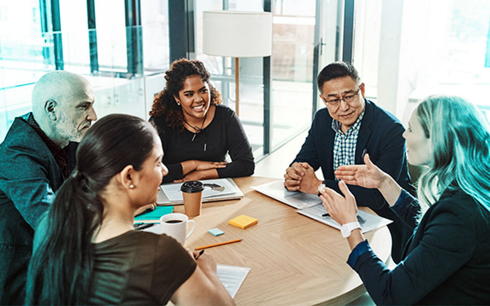 A team of happy professionals in a roundtable meeting