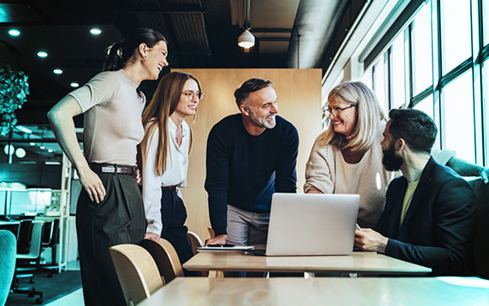 A team huddled around an office desk talking