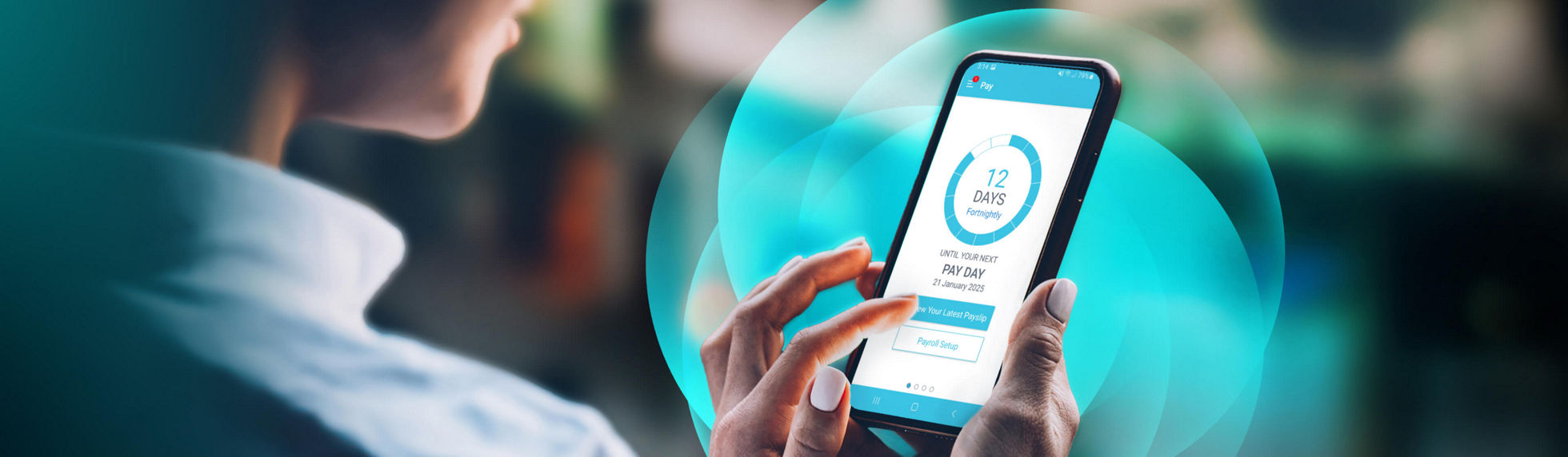 A person holding a mobile phone with the Mypay app presented on the screen and Datapay visual device in the background