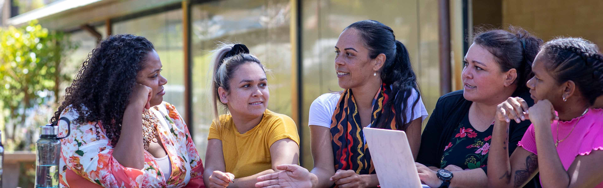 An Aboriginal community project team having a team discussion outside