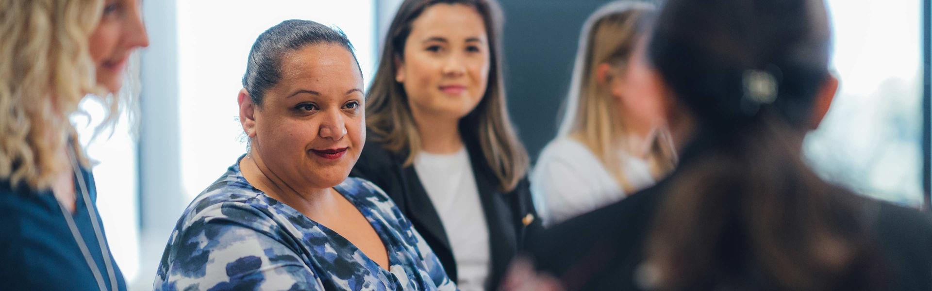 A group of business women talk to each other