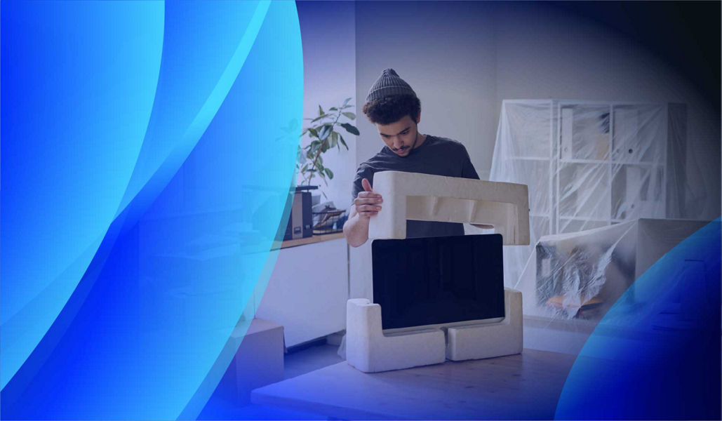 A man unboxing IT equipment in an office