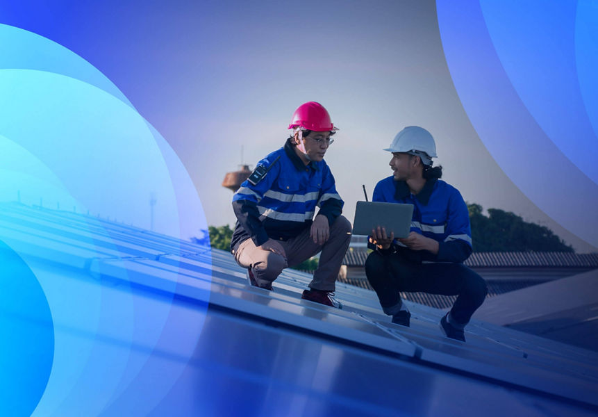 Two energy specialists on a roof running tests on a laptop 